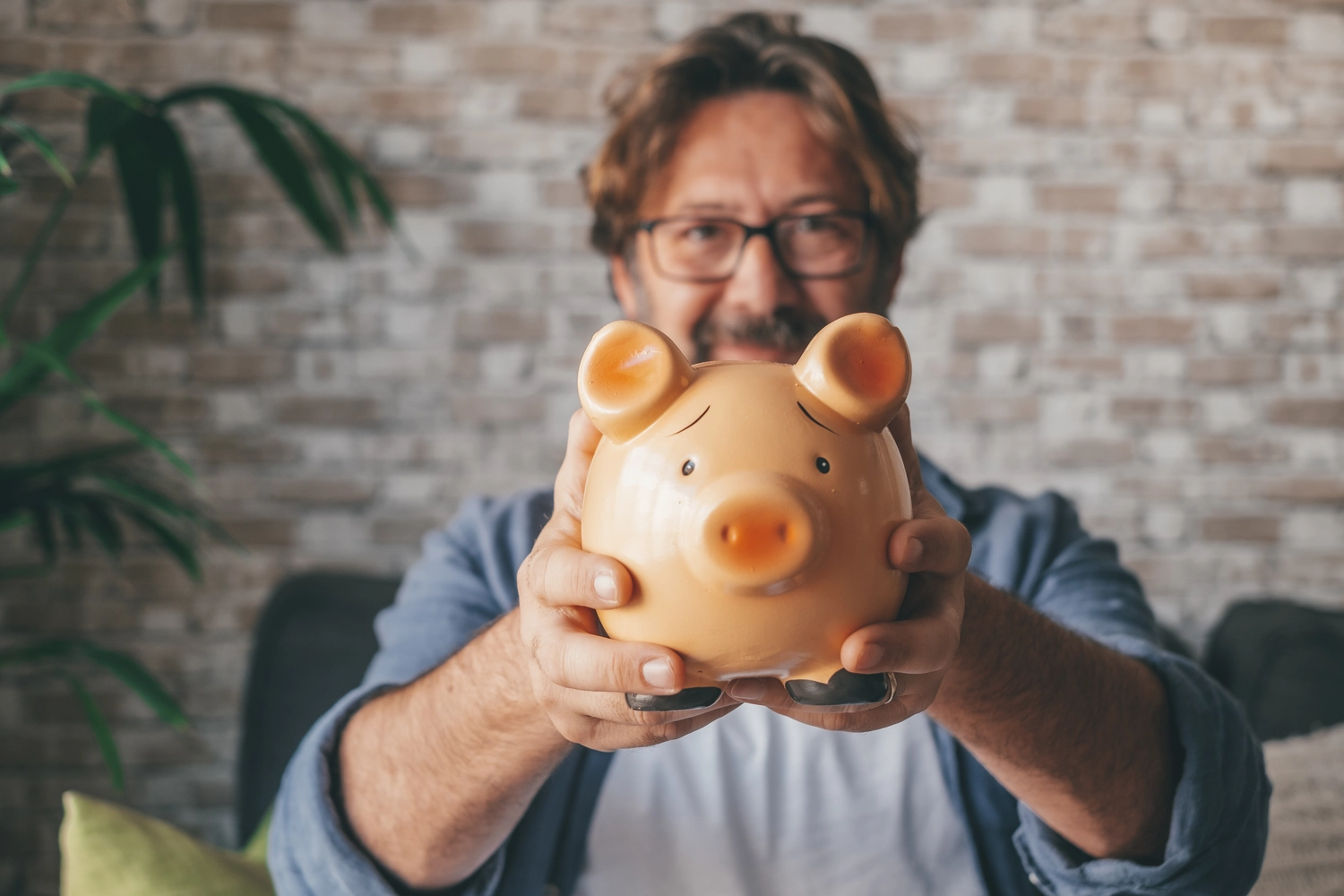 happy-mature-man-showing-piggy-bank-to-save-money-2022-08-29-18-15-28-utc